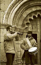 Jose Maria Canfran, tocando la dulzaina ante la puerta romanica de Villacadima
